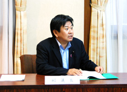 記者会見を行う岡田副議長の画像